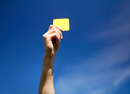 Referee's hand holding yellow card